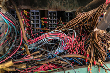Old multicolored wires in the electrical cabinet of mechanical equipment.