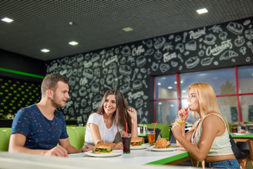 View from side of funny man talking with friends in cafe