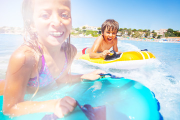 Boy and girl riding the wave on air mattresses