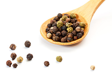 Different peppercorn in a wooden spoon.