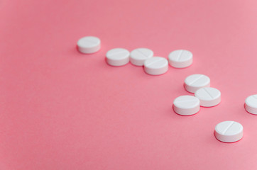  A handful of pills on pink background