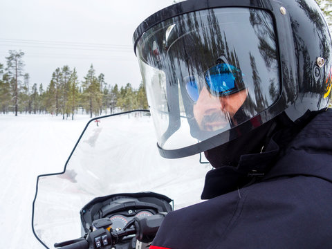 A Man on snowmobile in winter mountain