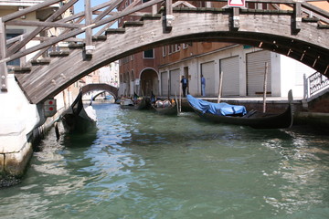 Gondola on canal in Venice, buildings and bridge in background Italy