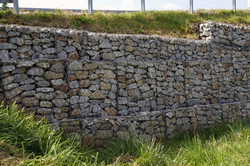 Strengthening the steep slope. A fragment of a retaining wall made of gabions.