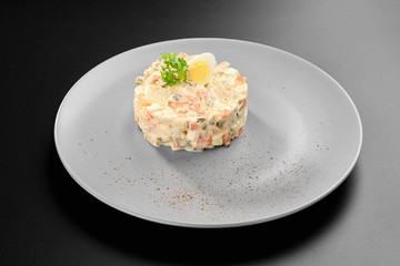 Olivier salad traditional russian dish new year menu restaurant black background grey plate studio mayonese