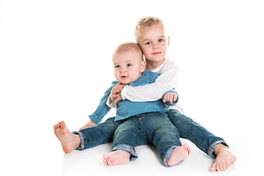 Two brother sit on the studio white background