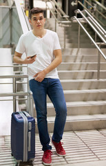 Fototapeta na wymiar Man with luggage and phone on stairs
