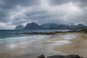 Strand mit Bergen im Hintergrund, bewölkter Himmel, Lofoten