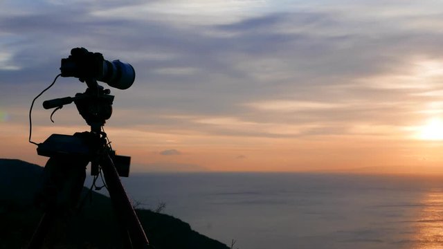 Professional camera taking picture film video of sunrise over sea surface, Greece Peloponnese Mani Peninsula. Time lapse 4K