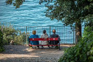 Anziani seduti su una panchina fronte mare, mentre parlano e pensano alla vita vissuta e si raccontano