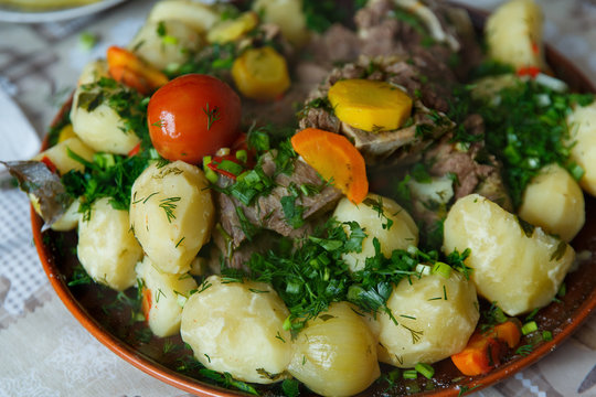 Hot boiled meat, vegetables and potatoes are served on a platter.