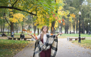 Happy woman throwing leaves