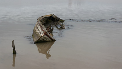 Sunken wooden boat in an estuary