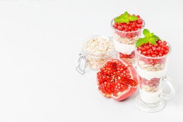 Pomegranate parfait - sweet organic layered dessert with granola flakes, yogurt and ripe fruit seeds.