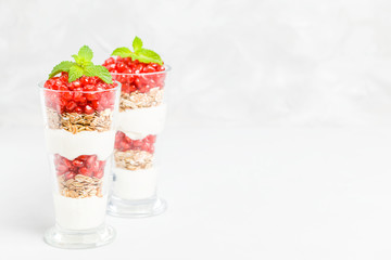 Pomegranate parfait - sweet organic layered dessert with granola flakes, yogurt and ripe fruit seeds.
