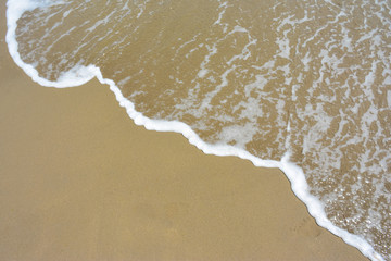 the sea wave flows to the sandy shore