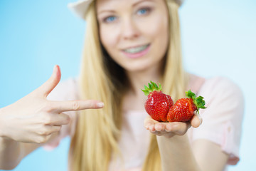 Girl showing fresh strawberries