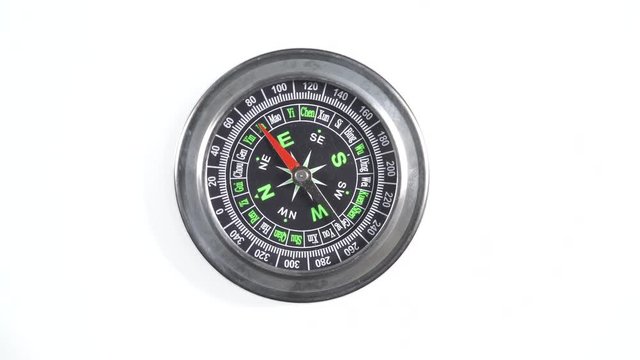 Black compass rotating on white background. Travel, tourism and exploration. Top down view