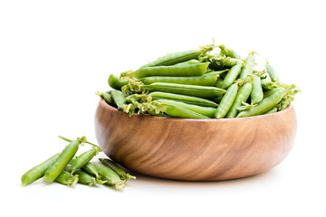 Fresh  green pea pods in wooden bowl isolated on white