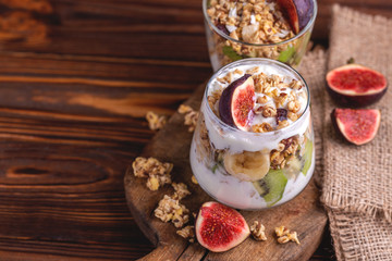 Granola with yogurt, bananas and figs. Copy space