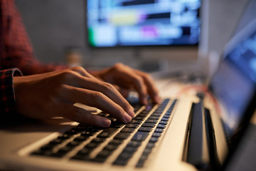 Hands of programmer writing code on laptop in office of IT company