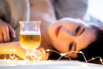Beautiful redhead woman with cup of coffee or cappuccino in a bed