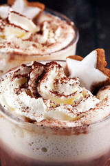 Hot chocolate cocoa with whipped cream on table.