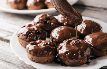 Covering homemade muffins with chocolate