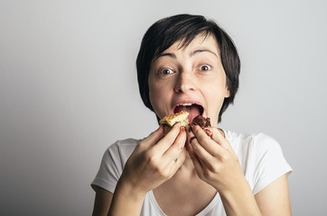 Beautiful young woman eats two different cakes