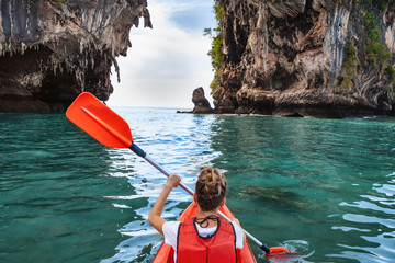 Woman paddles kayak in the tropical sea - obrazy, fototapety, plakaty