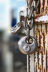 Round pad lock and a heavy chain on a steel bar door