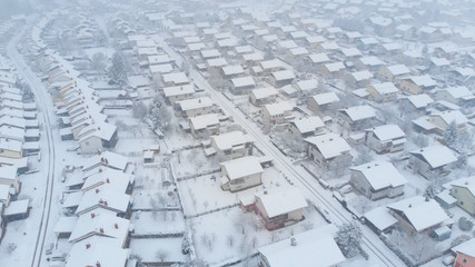 AERIAL: Pristine white snow covers the empty streets of a suburban neighborhood.
