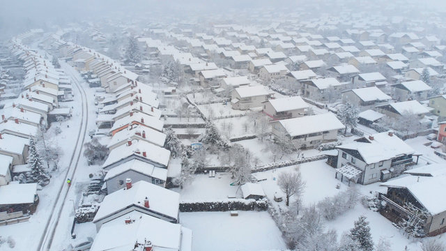 AERIAL: Flying Above The White Snowy Backyards On A Spectacular Winter Day.