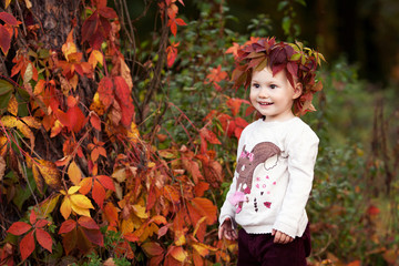 Autumn emotional portrait of little  girl. Pretty little girl with red grape leaves in autumn park. Autumn activities for children. Halloween and Thanksgiving time fun for family.