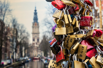 Naklejka premium Amsterdam, Holandia - 10 kwietnia 2018: Setki kłódek (tzw. Kłódek miłosnych) w Amsterdamie, Holandia. Blokady pozostawione jako obietnica dla bliskich na moście Kloveniersburgwal / Staalstraat.
