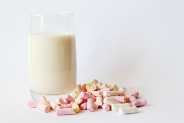 A glass cup of milk with colored marshmallows