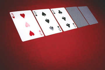 Cards for poker on a red background, 3 of a kind