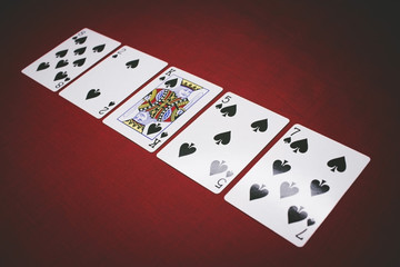 Cards for Poker on a red background, flush.