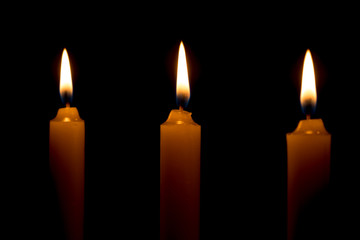 candle lit brightly against a black background