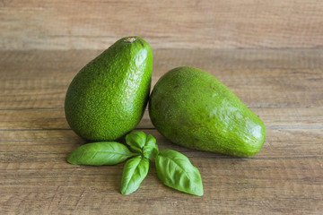 Avocados on a wooden table. Healthy food, diet. Two avocados