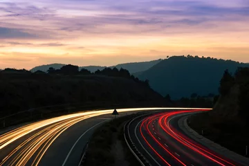 Cercles muraux Autoroute dans la nuit Sentiers de feux de circulation et paysage avec des montagnes