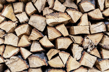 Firewood stack wall. Stack of wood prepared for winter and cold weather. Dry chopped oak wood. Wooden background texture