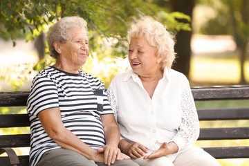 Elderly women resting on bench in park