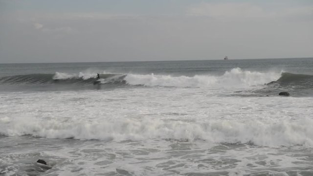 Surfers catching waves in Cascais, Portugal