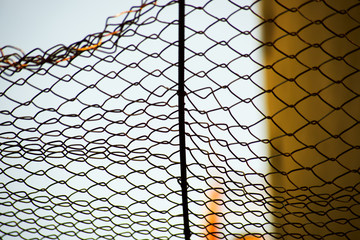Bent metal fence is from the grid in yellow tones