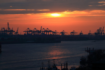 Containerterminal mit roter Sonne in Abendstimmung