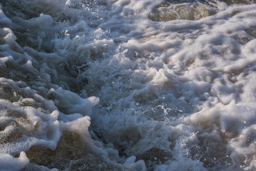 Artificial rapids on the river. Huge waves, splashes, dark water