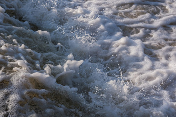 Artificial rapids on the river. Huge waves, splashes, dark water