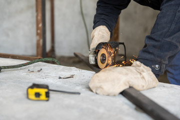 Metal cutting process with disc grinder. Hobby and work at home workshop, DIY. People at work, skills and abilities