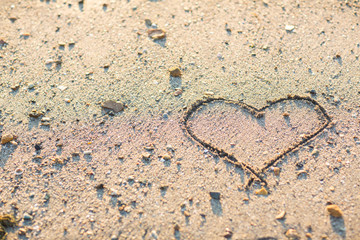 a heart in the sand on the beach.heart drawn on sand. horizontal composition.